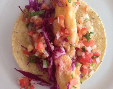 Taco de tiras de pescado capeadas con pico de gallo fresco, y col morada con cítricos
