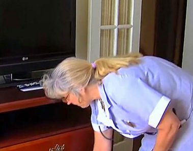 Limpiadora del hotel abre cómoda en la habitación de la pareja mayor